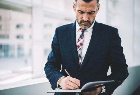 Man looking down and writing something.