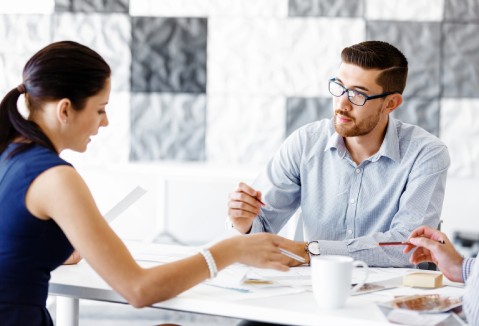 A woman and a man talking sitting at table.